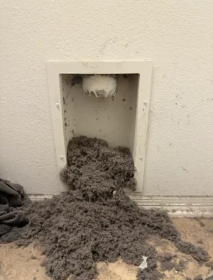 Dryer vent opening filled with lint before cleaning by Air i Am Duct & Chimney Services Houston