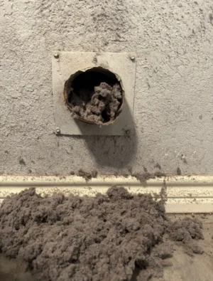 Clogged dryer vent filled with lint before cleaning by Air i Am Duct & Chimney Services Houston