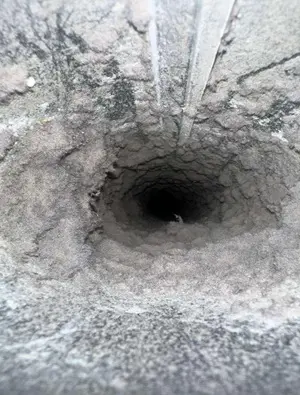 Dryer vent opening filled with lint before cleaning by Air i Am Duct & Chimney Services Houston