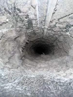 Dryer vent opening with excessive lint buildup before dryer vent cleaning